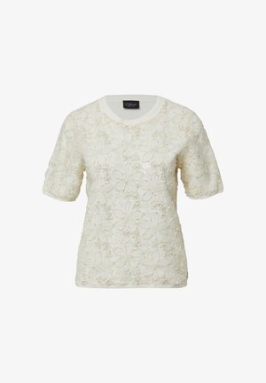 Kremowy krótki sweter z kwiatową koronkową nakładką i subtelnymi cekinowymi akcentami, okrągły dekolt i ściągacze na rękawach.