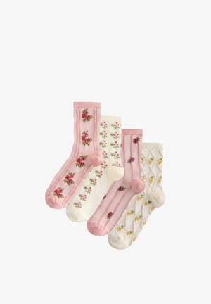 Four pairs of floral patterned socks in pink and cream tones, each featuring different flower arrangements and textured knit designs.