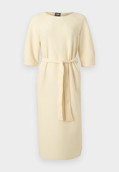 Κρεμ ριμπ φόρεμα μέχρι το γόνατο με 3/4 μανίκια και ζώνη από το ίδιο ύφασμα δεμένη στη μέση.