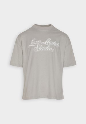 Lysegrå bomulds-T-shirt med rund hals, korte ærmer og broderet "Low Lights Studios" tekst i hvid på forsiden.