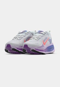Scarpe da corsa grigio chiaro con dettagli viola, tomaia in rete testurizzata e logo Nike rosa; presentano una suola imbottita e una suola in gomma nera.