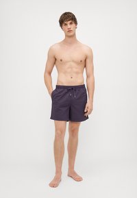 Fioletowe szorty kąpielowe wykonane z lekkiego, szybko schnącego materiału. Posiadają elastyczny pas ze sznurkiem do regulacji oraz boczne kieszenie.