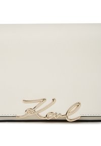 Borsa in pelle color crema con dettaglio lucido in oro "Karl" sul bordo inferiore anteriore.