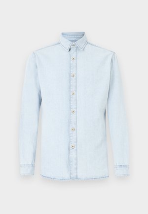 Camisa de ganga azul claro com mangas compridas, fecho frontal de botões e bainha arredondada. Apresenta botões em tom castanho claro e um design clássico de gola.