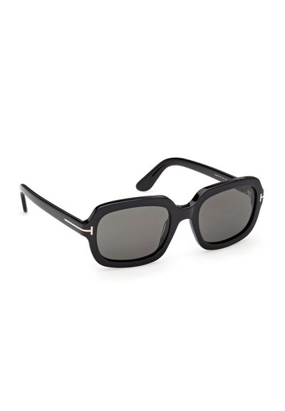 Lunettes de soleil carrées surdimensionnées noires avec des verres foncés et des branches fines ornées de petits accents métalliques près des charnières.