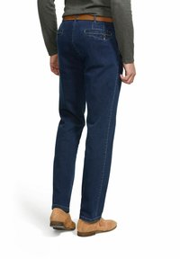 Jean en denim bleu foncé avec une coupe droite, présentant une ceinture en cuir marron, des poches arrière et un détail de couture subtil.