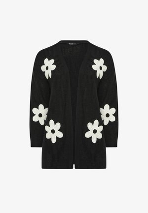 Musta avoimesta edestä oleva neuletakki, jossa on kuusi suurta valkoista päivänkakkarakuvioita hihoissa ja etusivuilla.