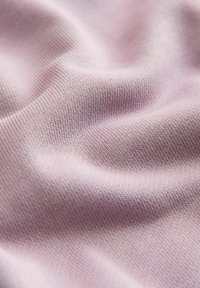 Tissu tricoté doux de couleur violet clair avec de petites mailles uniformes et de légers plis créant une surface texturée.
