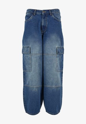 Keskmise sinise värvusega denimist cargo püksid, mis on kohati kulunud. Omavad mitmeid küljetaskuid, laia cuts ja vabalt langevat disaini.