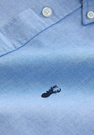 Lichtblauw geweven shirt met een zachte textuur, uitgerust met een kleine zwarte kreeft borduring en witte knopen op de kraag.