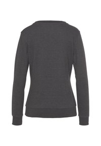 Grauer Langarmpullover mit Rundhalsausschnitt, figurbetontem Schnitt und gerippten Bündchen; glatte Textur ohne sichtbare Muster oder Akzente.