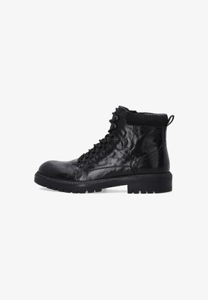 Schwarze Leder-Schnürkampfstiefel mit dicker Gummisohle und gepolstertem Knöchelkragen, von der Außenseite auf einem weißen Hintergrund gezeigt.