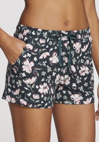 Bloemmotief shorts op een donkere achtergrond. Gemaakt van zachte stof, met een trekband in de taille en zijzakken. Het ontwerp bevat verschillende bloemenpatronen.