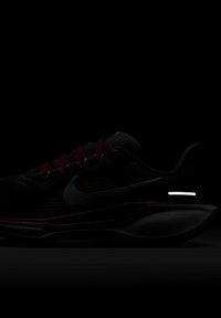 Bottines de course Nike avec une tige en maille noire et des lacets bordeaux. Présentent un accent réfléchissant sur le côté et une semelle rembourrée.