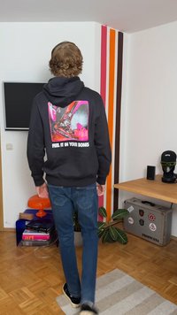 Sudadera negra con un gráfico colorido en la parte posterior que presenta zapatillas y el texto "SIENTELO EN TUS HUESOS." Material de algodón, corte relajado.