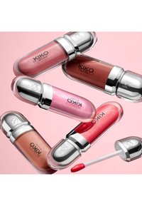 Five KIKO Milano lip gloss tubes in varying pink, red, and nude shades, one with open applicator on a pale pink background.
