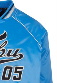 Blouson aviateur en satin bleu avec « Fubu 05 » brodé en noir et blanc sur le devant, col côtelé rayé en bleu, blanc et noir.