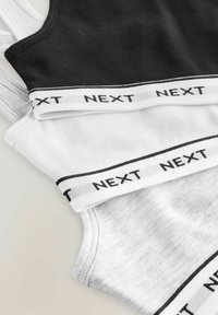 Zwarte, witte en grijze katoen tanktops in lagen, met contrasterende elastische banden waarin "NEXT" in het zwart is afgedrukt. Zachte, gladde textuur.
