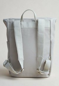 Zaino in tela grigia con due spallacci imbottiti, manico superiore e accessori in ottone dorato. Presenta un tessuto testurizzato per una maggiore durata.