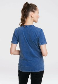 Short-sleeve blue denim t-shirt with a round neckline, relaxed fit, and a slightly faded texture; visible stitching along the sleeves.
