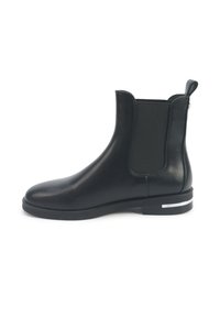 Zwarte leren enkelboot met elastische zijkant, trekband aan de achterkant, lage hak met een zilveren metallic accent.