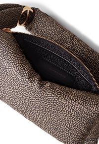 Borsa a spalla marrone e nera con un motivo, dalla superficie liscia, hardware dorato e una tasca interna con zip che presenta dettagli in rilievo.