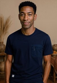 Navyblauwe T-shirt met korte mouwen, gemaakt van zachte stof, met een voorzak met rits en een klein logo op de zoom.