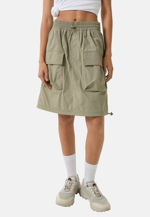 Cargo rok in licht olijfgroen, met een elastische tailleband, twee grote voorzakken en een verstelbare zoom met trekkoord.