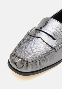 Zilveren leren instappers met een textuurfinish, mocassin-stiksel en een slanke band over de wreef voor extra detail.