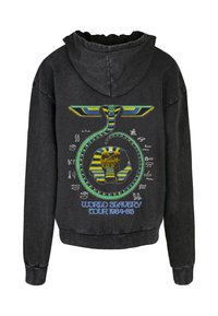 Svart hettegenser med et stort grafisk motiv av en slange kronet med blå og gule vinger, som omkranser et elefantmotiv med teksten: "VERDENSSLAVERYTURNÉ 1984-85."