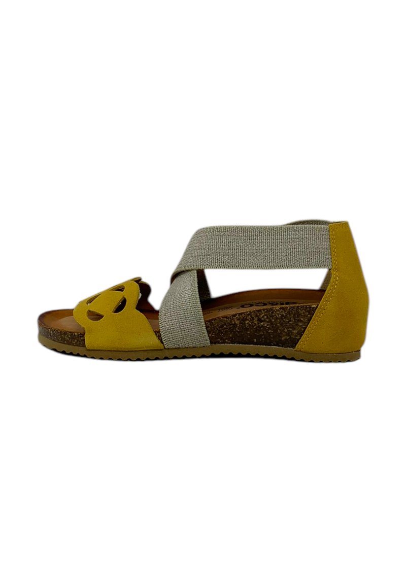 Sandalo in suede giallo con un design a ritaglio, dotato di una cinghia elastica grigia e di una soletta in sughero. Tacco basso a wedge e suola testurizzata.
