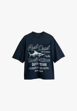 Tengerészkék rövid ujjú póló fehér horgász témájú szöveggel és marlin grafikával, rajta a "Reel Deal Hook & Line Outfitters" felirat.