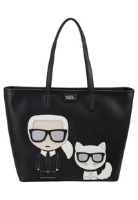 Zwarte draagtas met cartoonontwerpen van een figuur in een bril en een witte kat, vervaardigd van textuurachtig synthetisch materiaal met glanzende accenten.