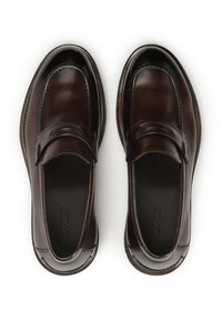 Mocasines de cuero marrón con una textura suave, punta redondeada, costuras decorativas y una silueta esbelta. Incluye un pequeño logo en relieve en el interior.