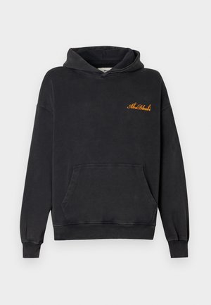 Black cotton hoodie with a front kangaroo pocket, loose fit, and an orange "Abu Dhabi" embroidered logo on the chest.