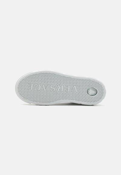 Sula av en sneakers, med en texturerad gummiyta och ett geometriskt mönster, mestadels ljusgrå med en cirkulär accent nära hälen.