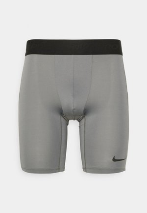 Grå sportshorts gjorda av ett smidigt, stretchigt material. Har ett svart midjeband med "NIKE PRO"-text och en liten svart logotyp vid fållen.