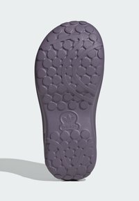 Suela de zapato de goma morada con textura de burbuja redondeada, que presenta un diseño ondulado, logotipo en relieve y acabado suave.