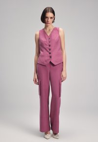 Lavender linnen vest met een V-hals en vijf knopen, gecombineerd met cargo-stijl broeken met zijzakken en een wijde pijp.