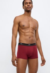 Bordeauxrode boxer briefs gemaakt van zachte katoen met een zwarte tailleband met logo. Strakke pasvorm en mid-dij lengte met een gladde textuur.