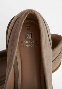 Scarpe slip-on in suede marrone con una morbida fodera interna, cuciture decorative e il marchio "FOREVER COMFORT" sulla soletta. Taglia 40.