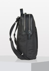 La borsa nera in nylon presenta una forma elegante con numerose tasche con cerniera, un bordo in pelle texturizzata e una tracolla regolabile.