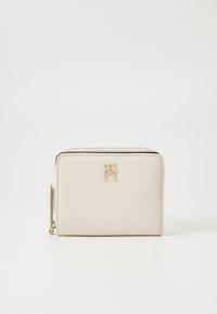 Portefeuille en cuir beige avec une texture lisse, présentant un accent logo doré et une fermeture éclair le long du bord supérieur. Design rectangulaire compact.
