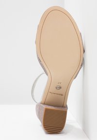 Vue unique d'une sandale à talon rose pailleté de taille 37 avec un talon bloc et une semelle antidérapante beige portant la marque Tamaris.