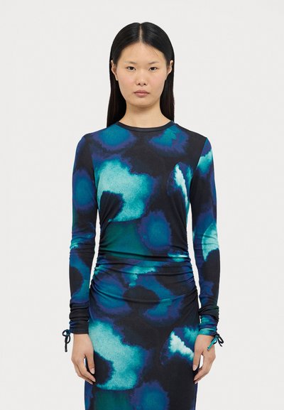 Robe à manches longues dans un motif tie-dye bleu foncé et vert, fabriquée en tissu extensible, présente un détail froncé à la taille et des manches ajustées.