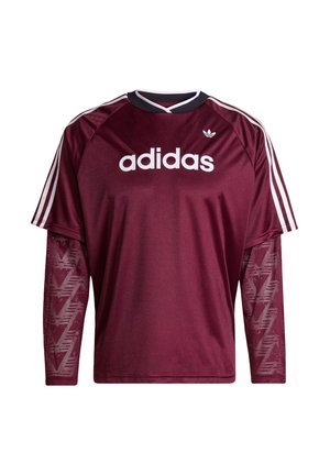 Chemise à manches longues Adidas couleur marron avec manches en mesh, logo blanc et rayures sur les épaules, col noir et blanc, vue de face.