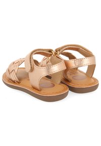 Bronzen leren sandalen met gevlochten bandontwerp, open achterkant, verstelbare sluiting en bruine rubberen zool. Ideaal voor warm weer.