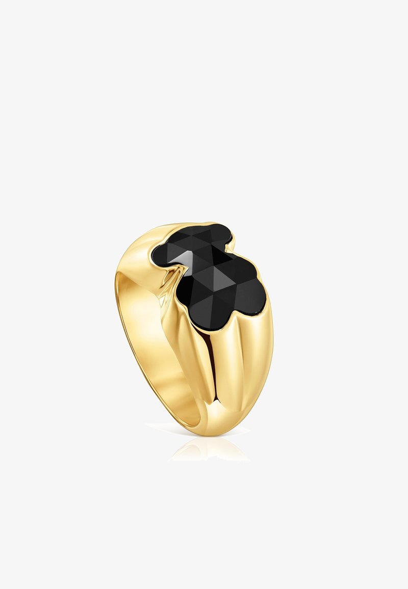 Bague en or avec un large anneau présentant une pierre précieuse facettée noire en forme d'ours en peluche stylisé sur le dessus.