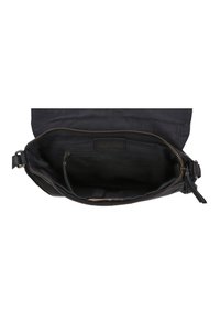 Interno di una borsa nera in tela con chiusura a zip, dotata di un grande scomparto e di una tasca più piccola con zip, con accenti in pelle visibili.