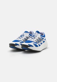 Sportskor med en blå och vit mesh-överdela, texturerade detaljer, en tjock vit mellansula och en svart gummisula.